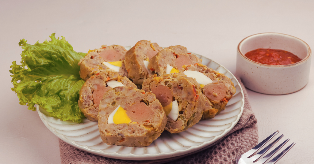 Plated meatloaf rolls with a side of salad and ketchup on a white background
